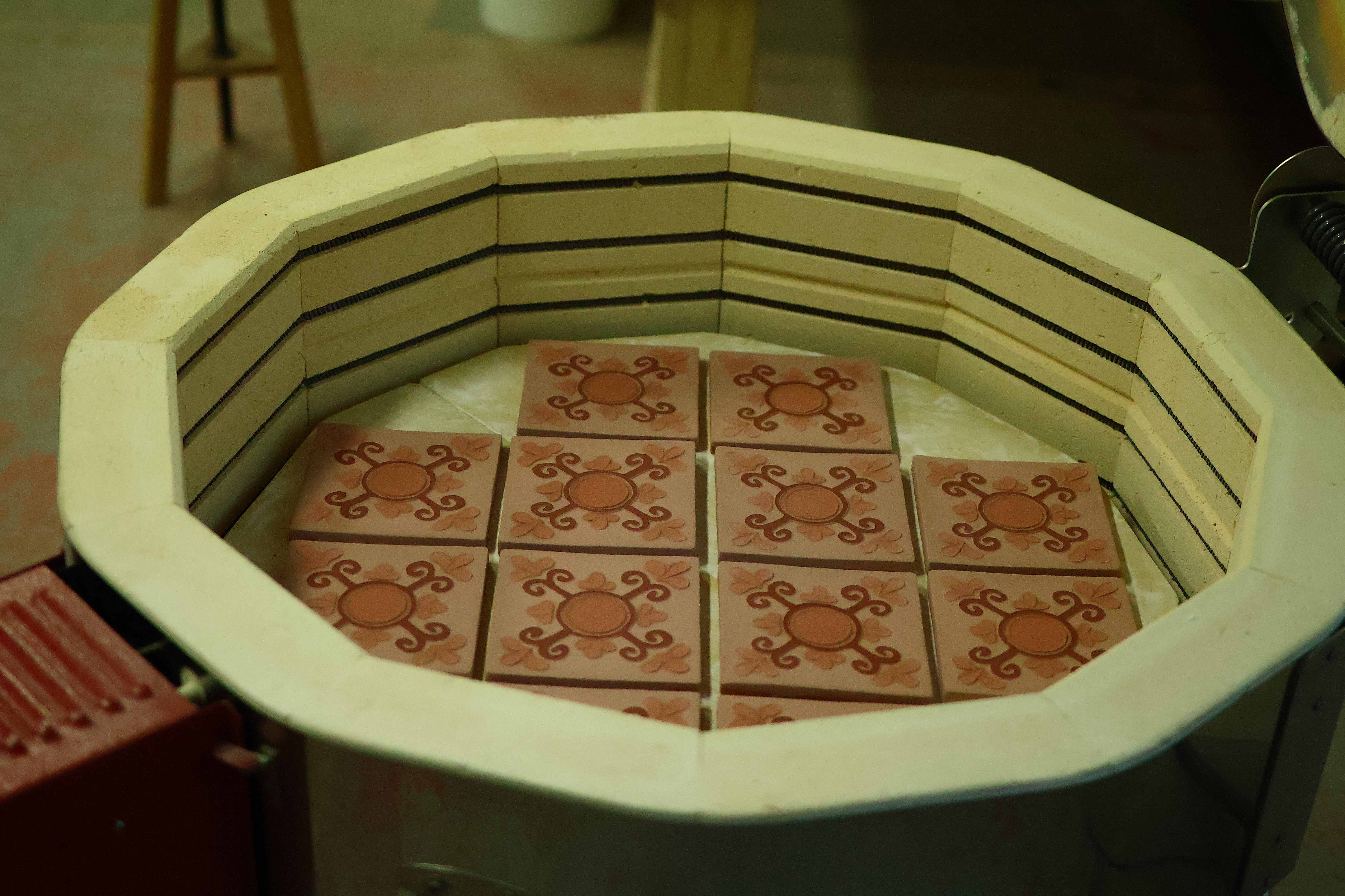 A grid of carved Courtyard tiles loaded inside the studio's octagonal kiln, ready to be fired